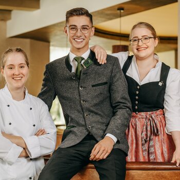 Zwei junge Damen und ein junger Mann lächelnd bei Antritt ihres Jobs in Schmallenberg im Sauerland.