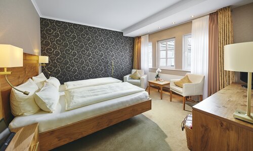 Ein Zimmer mit Holzmöbeln und Sitzecke im Hotel Deimann.