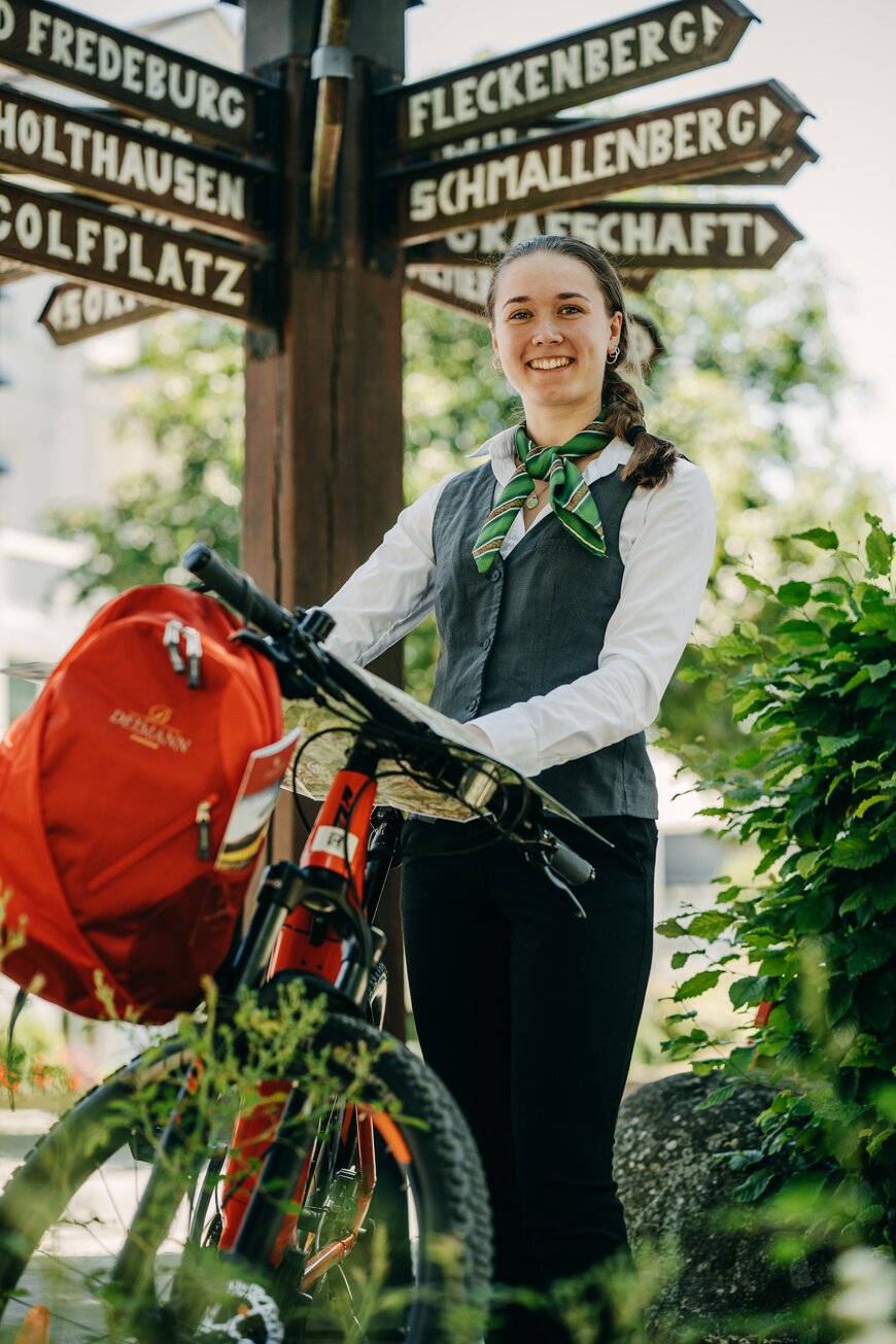 Junge Dame mit einem Mountainbike im Grünen während ihrer Ausbildung in Schmallenberg im Sauerland.